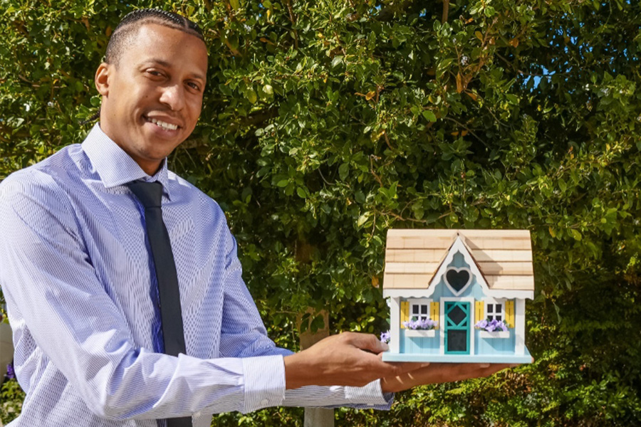 Realtor Holding a Miniature House