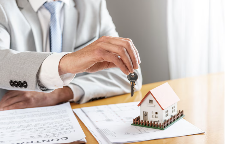 Realtor Holding a Miniature House